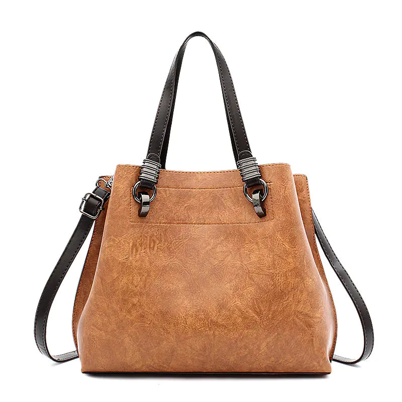 Brown leather handbag with black straps on a white background
