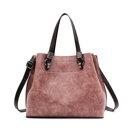 Pink handbag with black straps on a white background