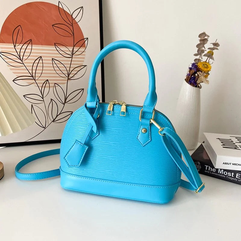 Blue handbag on a white surface with a decorative background