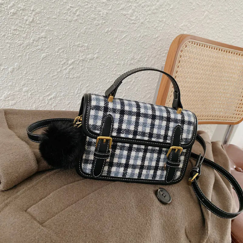 Plaid handbag with black accents on a beige couch