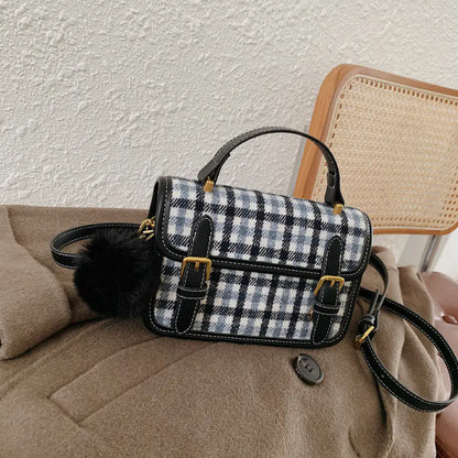 Plaid handbag with black accents on a beige couch