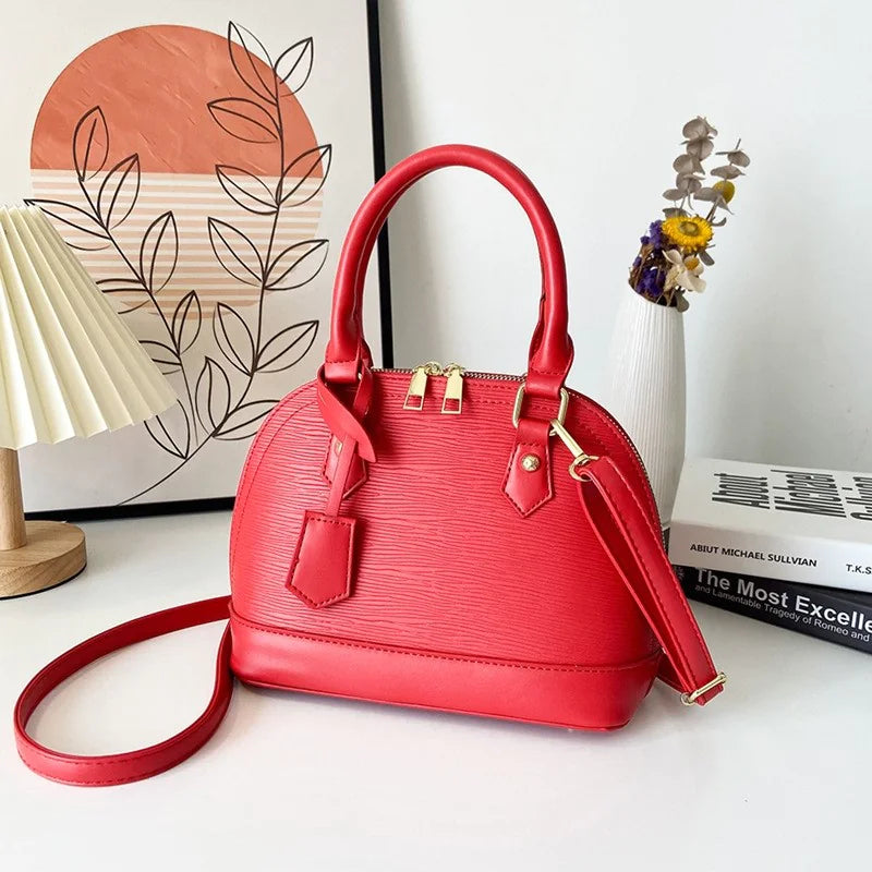Red handbag on a white surface with a decorative background